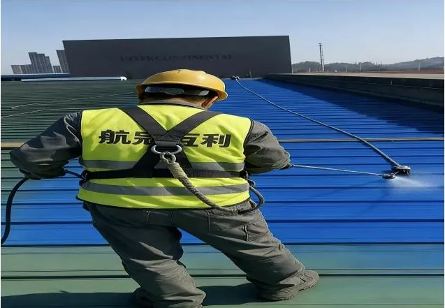 施工人员在彩钢瓦屋面喷涂防锈面漆